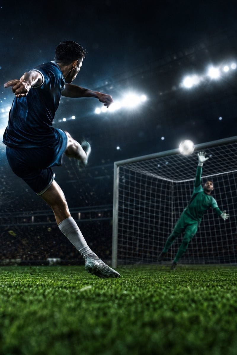 Player volleys the ball under stadium lights